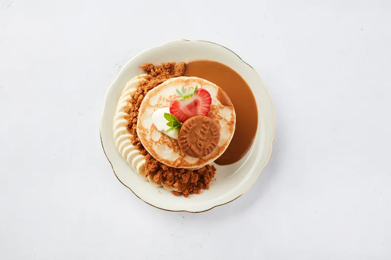 Pannenkoek met aardbei, room, speculoos en banaan op een bord